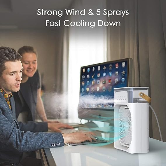 A person using the 3-in-1 Portable Air Conditioner Fan at a desk, enjoying strong wind and cool mist.